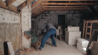 Man breaks brick wall with sledgehammer. Slow motion.