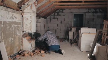 Man breaks brick wall with sledgehammer. Slow motion.
