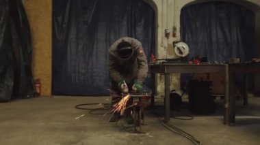 Bir işçi metal bir parçayı öğütür. Kıvılcım saçıyor. Yüksek kalite 4k görüntü