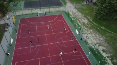 İnsansız hava aracı canlı bir sahada heyecan verici bir futbol maçı yakalıyor, oyuncular hareket halinde.