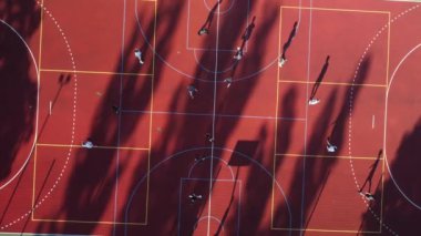 İnsansız hava aracı canlı bir sahada heyecan verici bir futbol maçı yakalıyor, oyuncular hareket halinde.