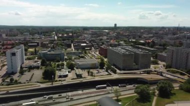 Bu, hareketli şehir binaları ve yemyeşil alanlarla kesişen yoğun bir otoyolu gösteren büyüleyici bir hava manzarası.