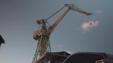 Etkileyici bir vinç bulutlu gökyüzüne karşı dimdik ayakta duruyor, inanılmaz bir mühendislik harikası sergiliyor.