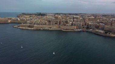 Göz kamaştırıcı bir hava fotoğrafı, resimli sahil şeridinde bir sahil kasabasını ve yakınlarda teknelerin açıldığını gösteriyor.