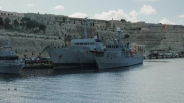 Pahalı bir limanda zengin bir tarihi arkaplana karşı kenetlenmiş deniz gemilerinin gerçekten huzurlu bir görüntüsü.