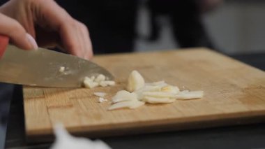 Kadın eli sarımsağı kesiyor. Yüksek kalite 4k görüntü