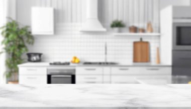 Modern mutfak, ahşap masa ve beyaz mobilyalar.