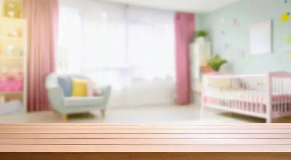 Tasarım ve dekorasyon kavramları için bulanık bebek odası arka planına sahip boş tahta masa