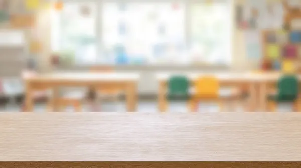 Bulanık okul odası arka planında boş ahşap bir masa.