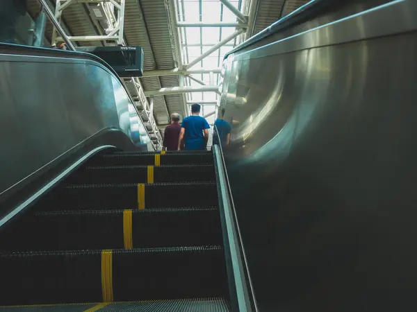 İnsanlar yürüyen merdiven üzerinde