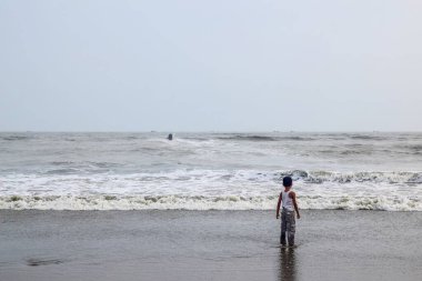 Sahildeki beyaz elbiseli adam. Cox 's Bazar plajı dünyanın en uzun plajıdır. Bangladeş 'te çok popüler bir tatil beldesi..