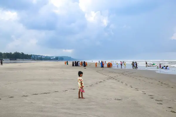 Denizin ortasında yürüyen bir sürü insanın olduğu güzel bir sahil manzarası. Cox 's Bazar plajı dünyanın en uzun plajıdır. Bangladeş 'te çok popüler bir tatil beldesi..