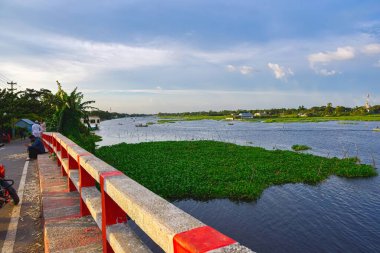Şehirdeki nehir manzarası. Nehrin güzel manzarası, bulutlu gökyüzü ve yeşil doğa. 
