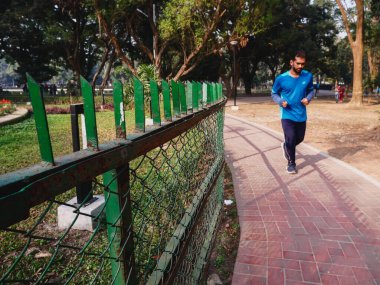 Genç adam şehirde koşuyor.