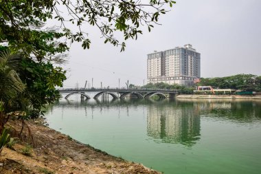 Şehirdeki bir göldeki yüksek katlı bir binanın manzarası.