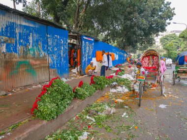 İnsanlar sokakta çiçek satıyor.