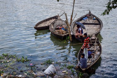 Tekneler nehirde duruyor ve insanlar balık yakalıyor.