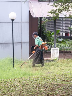 Çim biçme makinesiyle kesim yapan bir adam. 