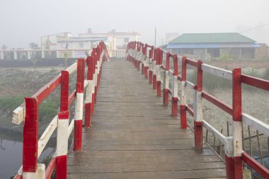 Sisin yumuşak dalları sakin sabahı örterken ilkokulun yakınındaki geleneksel ahşap bir köprü mistik bir manzaranın gizli bir mücevheri gibi ortaya çıkıyor. Ballı bir renge bürünmüş ahşap, tarihin belli belirsiz izlerini taşıyor..