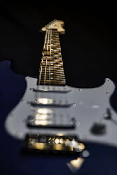 Blue electric guitar upright after concert out of focus