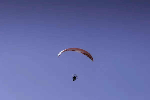 Man seen paragliding in a clear sky in the Sierra Norte de Sevilla, Spain