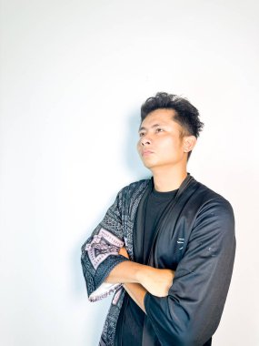 Siyah kimono tarzı bornoz giyen genç bir adam kararlı bir ifadeyle parmağını ileri doğru doğrultuyor. İddialı vücut dili liderlik, motivasyon ve cesaret veriyor. Bu resim otoriteyle ilgili kavramlar için mükemmeldir., 