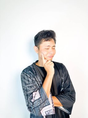 Siyah kimono tarzı bornoz giyen genç bir adam kararlı bir ifadeyle parmağını ileri doğru doğrultuyor. İddialı vücut dili liderlik, motivasyon ve cesaret veriyor. Bu resim otoriteyle ilgili kavramlar için mükemmeldir., 