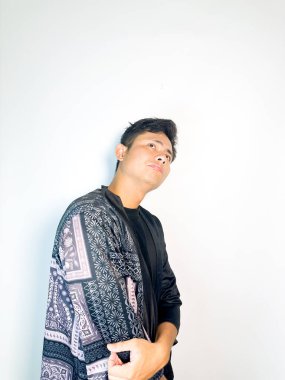 Geleneksel desenli siyah bornoz giyen genç bir adam, kafası karışık bir ifadeyle yana bakıyor. Onun hafif eğimli kafası ve çatık kaşları şüphe, merak ya da belirsizlik taşır, bu görüntü kafa karışıklığı, karar-mak temaları için uygundur