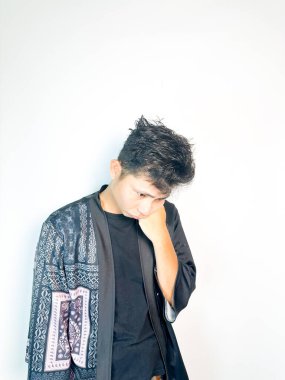 Geleneksel desenli siyah bornoz giyen genç bir adam, kafası karışık bir ifadeyle yana bakıyor. Onun hafif eğimli kafası ve çatık kaşları şüphe, merak ya da belirsizlik taşır, bu görüntü kafa karışıklığı, karar-mak temaları için uygundur