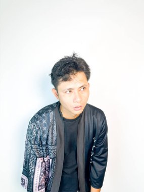 Geleneksel desenli siyah bornoz giyen genç bir adam, kafası karışık bir ifadeyle yana bakıyor. Onun hafif eğimli kafası ve çatık kaşları şüphe, merak ya da belirsizlik taşır, bu görüntü kafa karışıklığı, karar-mak temaları için uygundur