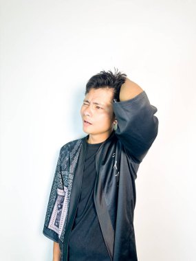 Geleneksel siyah bornoz giyen genç bir adam düşünceli görünürken işaret parmağıyla hareket ediyor. Bu ifade bir fikri veya farkındalığı akla getiriyor, beyin fırtınası, ilham ve problem çözme gibi kavramlara uygun kılıyor..