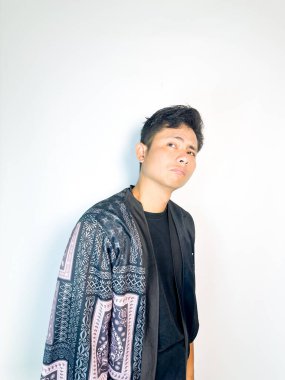 Geleneksel siyah bornoz giyen genç bir adam düşünceli görünürken işaret parmağıyla hareket ediyor. Bu ifade bir fikri veya farkındalığı akla getiriyor, beyin fırtınası, ilham ve problem çözme gibi kavramlara uygun kılıyor..