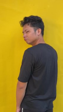 Sarı gömlekli genç adam.