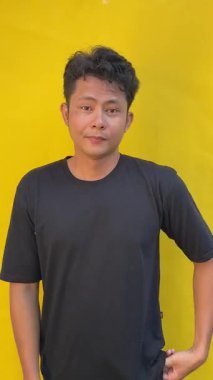 Sarı gömlekli ve siyah gömlekli genç Asyalı gülümsüyor.