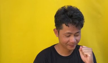 Asyalı adam üzgün ve eğleniyor.