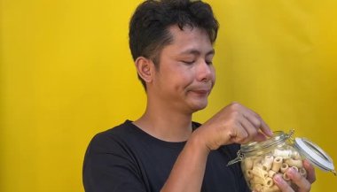 Adamın biri elinde bal kavanozuyla yumurta tutuyor.