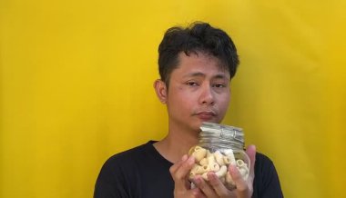 Genç Asyalı adam cips yiyor.