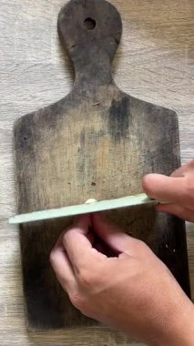 Bir adam odun kesmek için bıçak kesiyor.