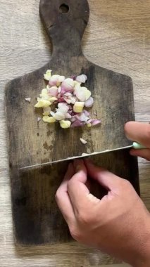 Tahtadaki kesiğe soğan, bıçakla tahta kesme tahtasına tahta tahtaya bıçak saplama, tahta kesme tahtasına bir el.