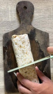 Şef peynirli, bıçaklı ve bıçaklı bir sandviç hazırlıyor. yemek yapmak.