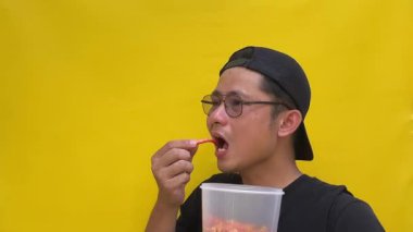 Gözlüklü ve siyah gömlekli genç Asyalı adam.