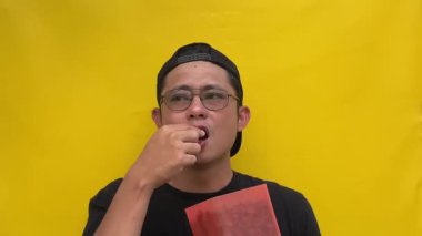 Sarı tişörtlü, gözlüklü Asyalı adam.