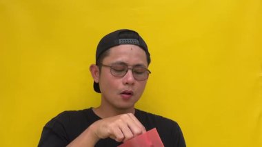 Gözlüklü, kırmızı tişörtlü, sarı tişörtlü Asyalı bir adam portresi.