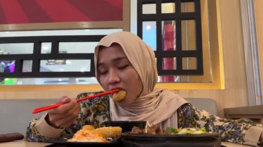 Suşi yiyen Asyalı kadın.