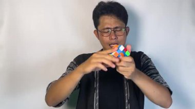 Genç Asyalı bir adam elinde bir küp tutuyor.