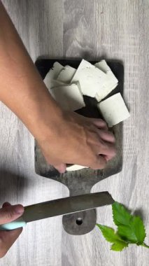 Tahta üzerinde yeşil çay yaprakları hazırlayan kadın.