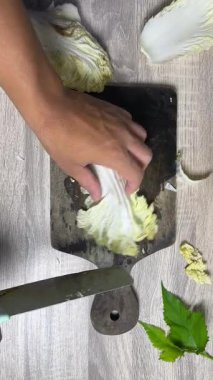 Tahtada beyaz bir soğan kesiyor.