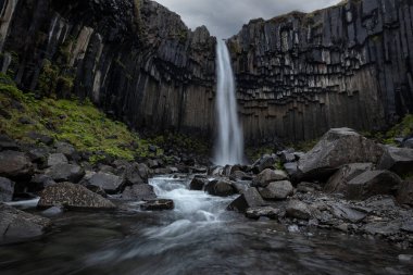 Svartifoss Şelalesi ve Güney İzlanda 'daki Skaftafell Ulusal Parkı' nda siyah bazalt sütunlar.