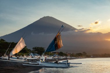 Amed köyü, Bali, Endonezya 'da gün batımında sahilde balıkçı tekneleri.