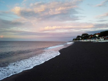 Kara kum plajı, dalgalar ve günbatımı Amed köyü, Bali, Endonezya